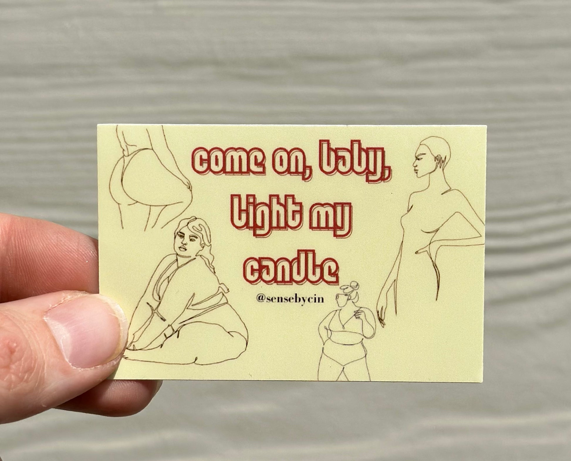 Sticker with "Come on, baby, light my candle" red text on a yellow background with women posing