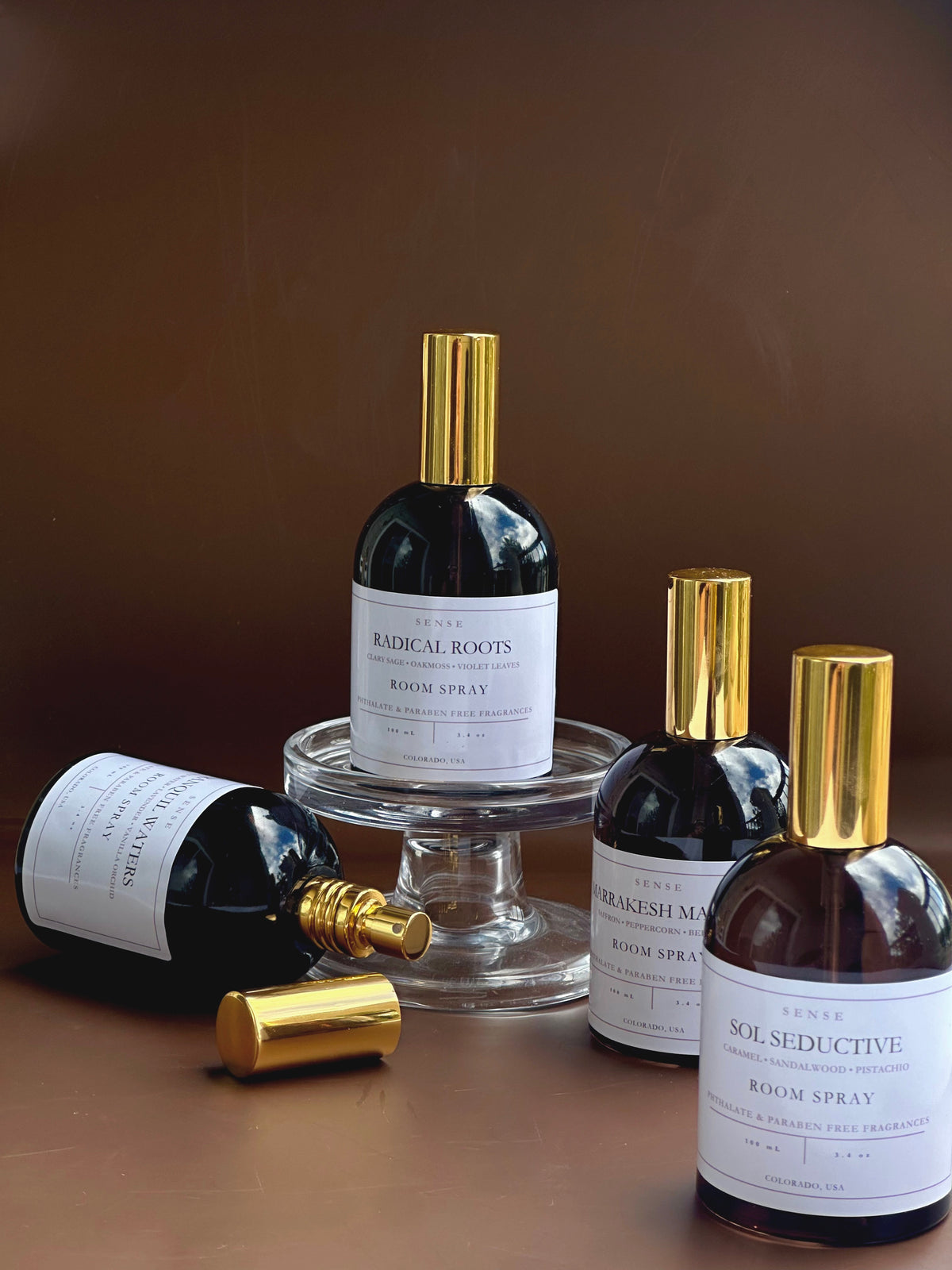 Collection of perfume bottles with gold caps on a brown background